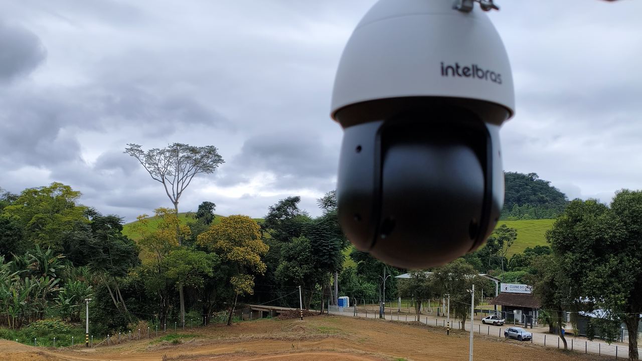 Câmera speed dome instalada em poste, cobrindo uma área aberta.